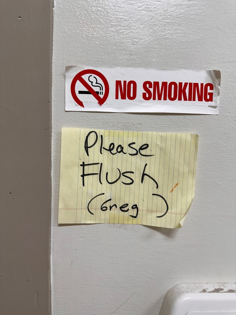 funny bathroom sign that mentions (Greg)