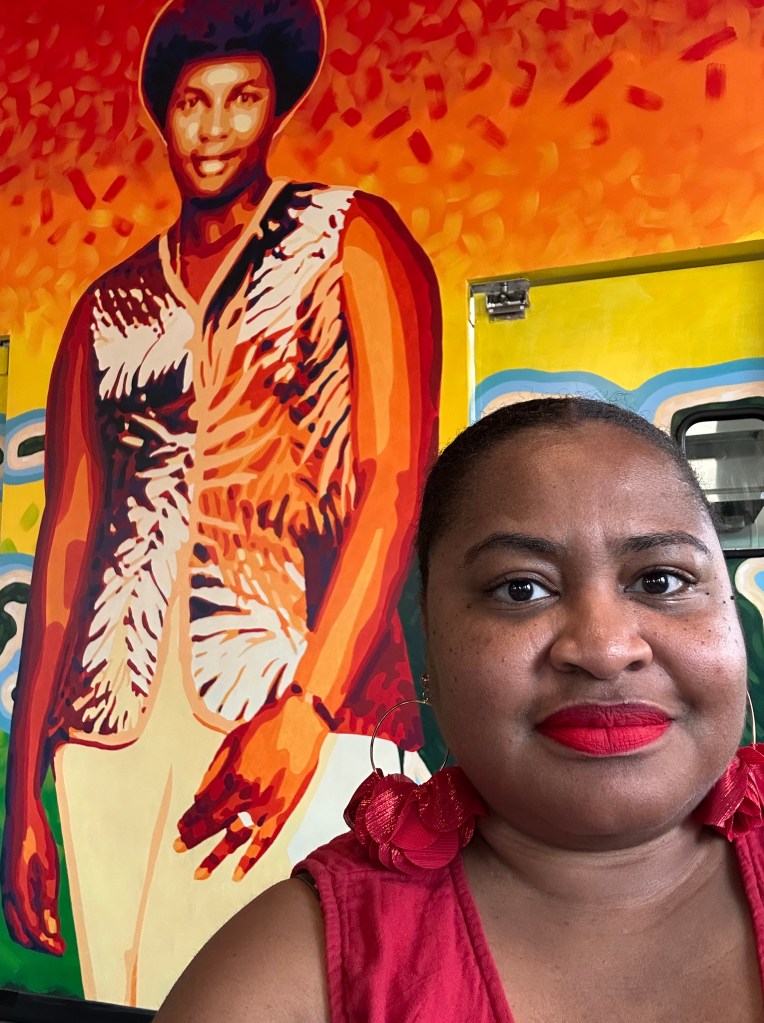 The author's selfie in front of artwork at Welton Cafe in Denver, CO