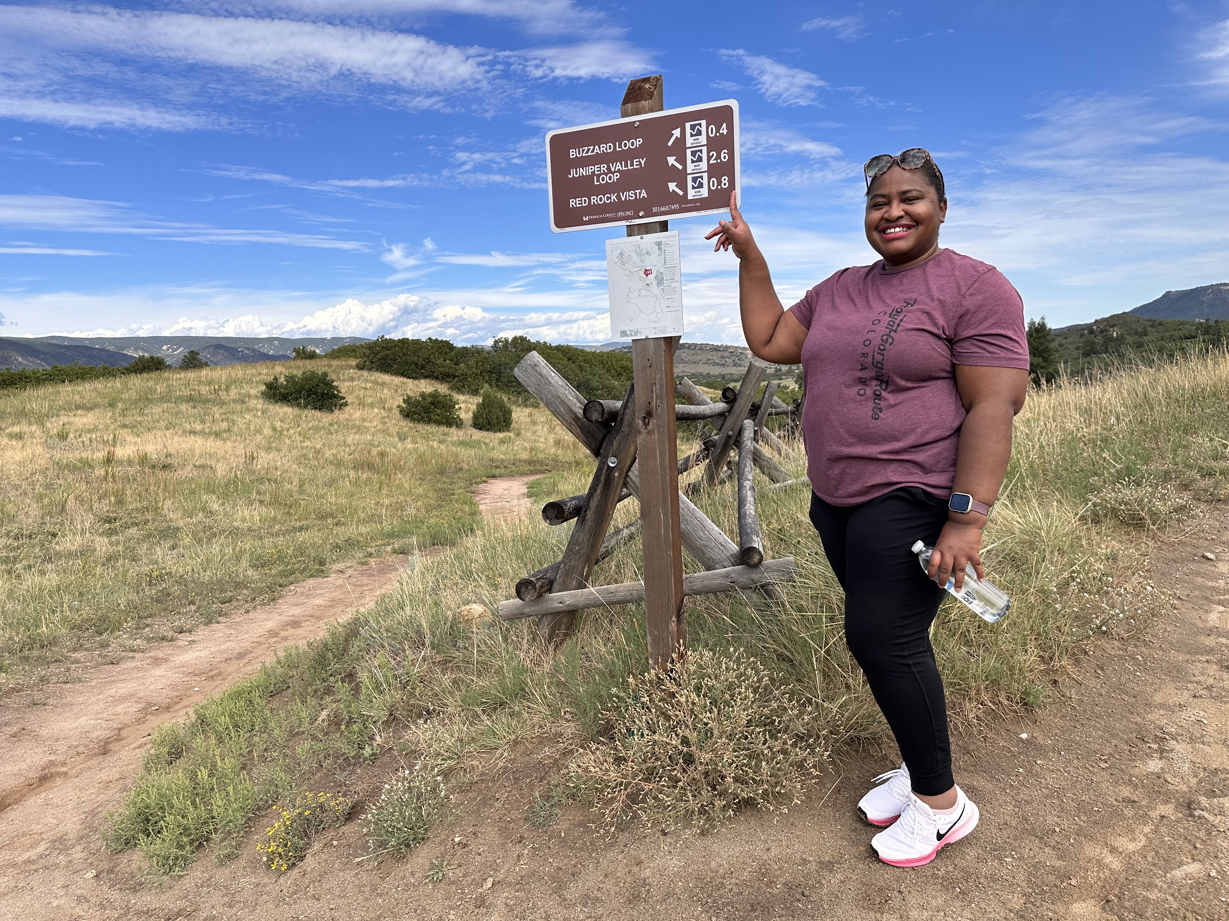 The author pointing to a trail sign in Larkspur, CO